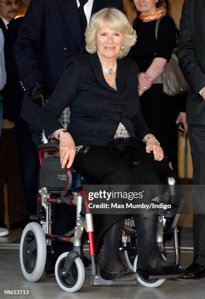 Camilla, Duchess of Cornwall is pushed in her wheelchair, after recently breaking her leg whilst walking in Scotland, as she leaves the Polish Social...