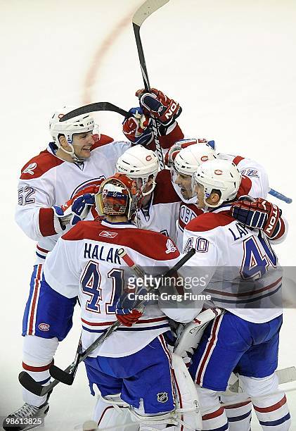 Tomas Plekanec of the Montreal Canadiens is mobbed by teammates after scoring the game winning goal in overtime against the Washington Capitals in...