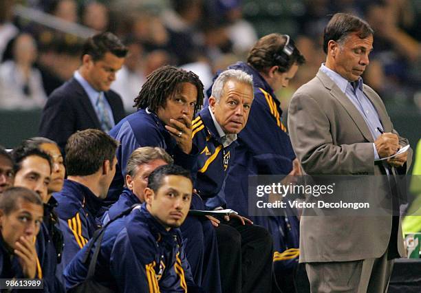 Assistant Coach Cobi Jones and Associate Head Coach Dave Sarachan of the Los Angeles Galaxy look on from the bench as head coach Bruce Arena jots...