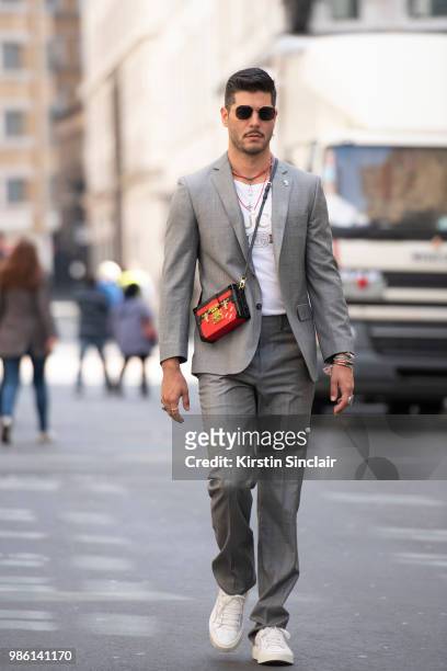 Digital influencer Kadu Dantas wears a Gucci T shirt, Louis Vuitton bag, Uniqlo sunglasses, Salvatore Ferragamo trainers, Brooks Brothers suit during...