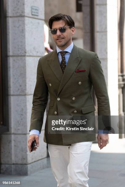 Model Johannes Huebl wears a Marc Anthony suit, Isaia tie, Incotex trousers during London Fashion Week Men's on June 9, 2018 in London, England.