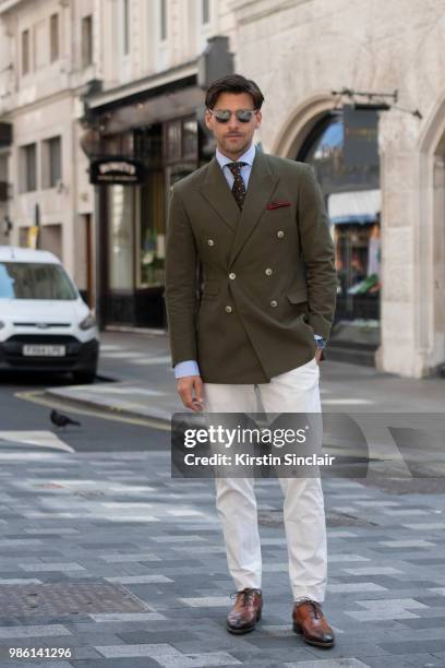 Model Johannes Huebl wears a Marc Anthony suit, Isaia tie, Santoni shoes, Incotex trousers during London Fashion Week Men's on June 9, 2018 in...