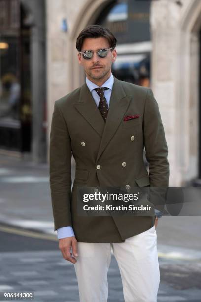 Model Johannes Huebl wears a Marc Anthony suit, Isaia tie, Incotex trousers during London Fashion Week Men's on June 9, 2018 in London, England.