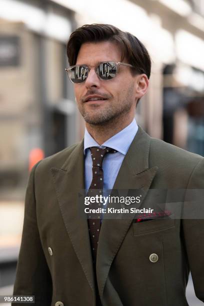 Model Johannes Huebl wears a Marc Anthony suit and an Isaia tie during London Fashion Week Men's on June 9, 2018 in London, England.