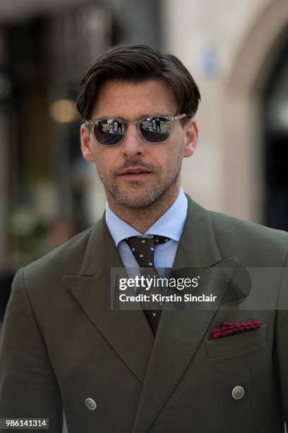 Model Johannes Huebl wears a Marc Anthony suit and an Isaia tie during London Fashion Week Men's on June 9, 2018 in London, England.