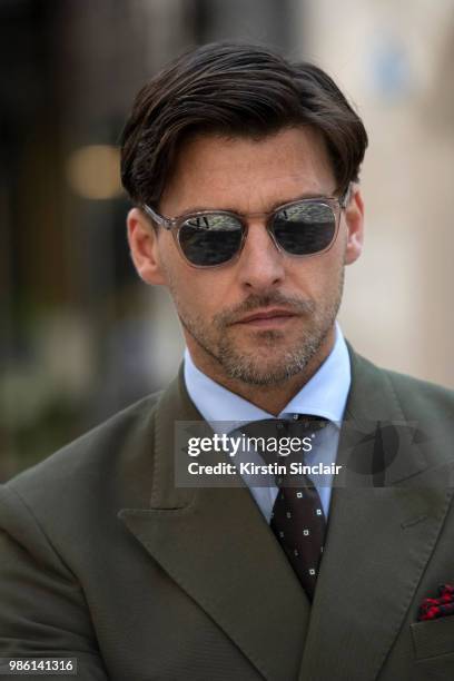 Model Johannes Huebl wears a Marc Anthony suit and an Isaia tie during London Fashion Week Men's on June 9, 2018 in London, England.