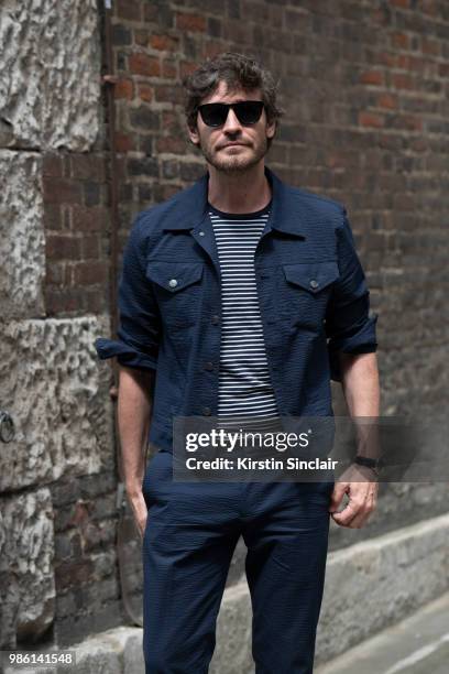 Model Robert Konjic wears a Club Monaco jacket and trousers and Jimmy Choo sunglasses during London Fashion Week Men's on June 9, 2018 in London,...