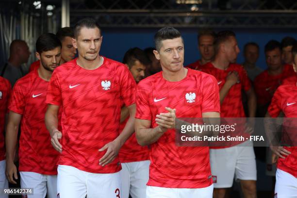 Robert Lewandowski and Artur Jedrzejczyk of Poland walk on the pitch for warm up prior to the 2018 FIFA World Cup Russia group H match between Japan...