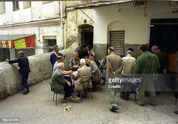 Picture taken in May 2000, shows elderly people playing cards in a coffee shop of the Kasbah quarter in Algiers, after the owner decided recently to...
