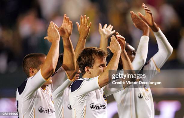 Bryan Jordan, Juninho, Mike Magee and Alex Cazumba of the Los Angeles Galaxy salute their fans after their 2-1 victory over Real Salt Lake in their...