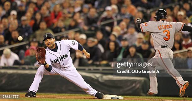 First baseman Casey Kotchman of the Seattle Mariners stretches for the throw against Cesar Izturis of the Baltimore Orioles at Safeco Field on April...