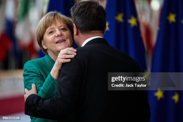 German Chancellor Angela Merkel greets Luxembourg's Prime Minister Xavier Bettel as they arrives at the Council of the European Union on the first...