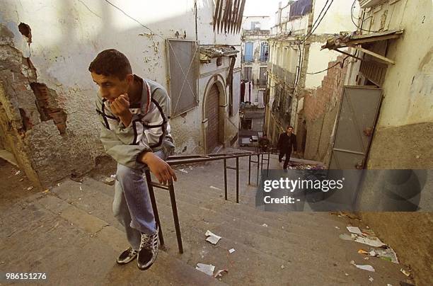 Un jeune homme est assis en haut d'un escalier de la casbah d'Alger, le 10 février 2000.