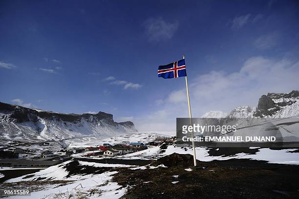 An Icelandic flag flies over Vik, a village sitting at the base of the Myrdalsjokull glacier, which is part of the ice cap sealing the Katla volcano,...