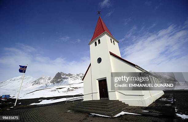 An Icelandic flag flies next to a church in Vik, a village sitting at the base of the Myrdalsjokull glacier, which is part of the ice cap sealing the...