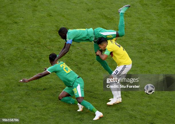 Radamel Falcao of Colombia is tackled by Cheikhou Kouyate and Keita Balde of Senegal during the 2018 FIFA World Cup Russia group H match between...