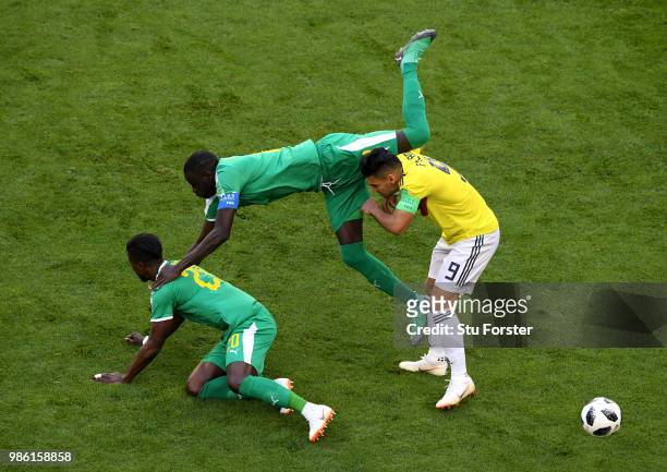 Radamel Falcao of Colombia is tackled by Cheikhou Kouyate and Keita Balde of Senegal during the 2018 FIFA World Cup Russia group H match between...