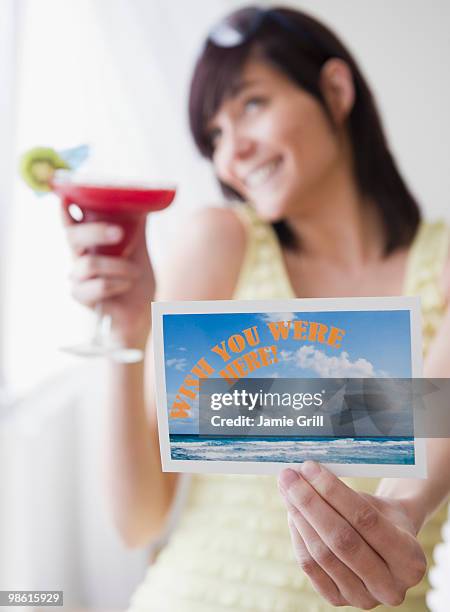 young woman holding tropical drink and post-card - escrita ocidental imagens e fotografias de stock