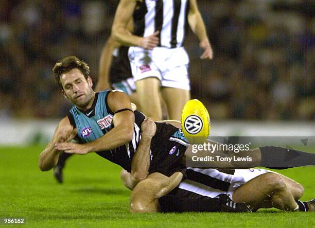 Darryl Wakelin for Port Adelaide handballs as he is tackled by Tyson Lane for Collingwood in the round 8 AFL match between Port Power and the...