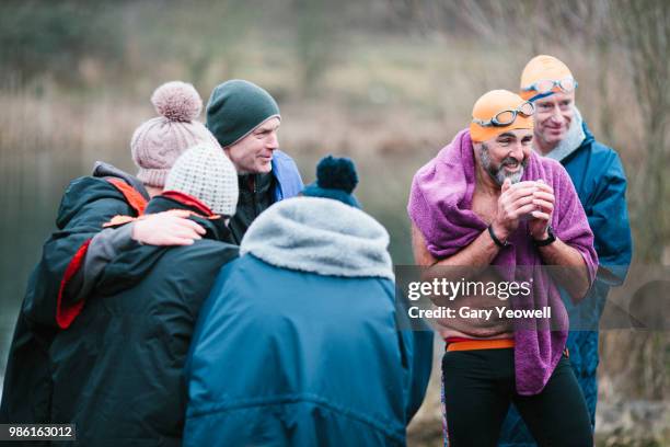 Mixed group of open water swimmers relaxing after an event