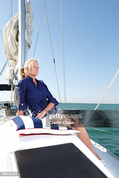 woman sitting on a pillow on a sailboat - newoutdoors stock pictures, royalty-free photos & images