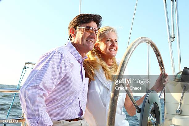 healthy active couple on sailboat at sea. - newoutdoors stock pictures, royalty-free photos & images