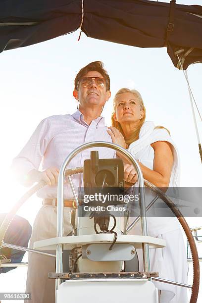 healthy active couple on sailboat at sea. - newoutdoors stock pictures, royalty-free photos & images