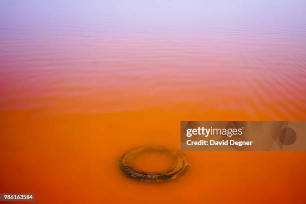 An abandoned tire rests in Lac Rose on the edge of Dakar, Senegal. Lac Rose is a saline lake that gets its color from a special type of algae and the...