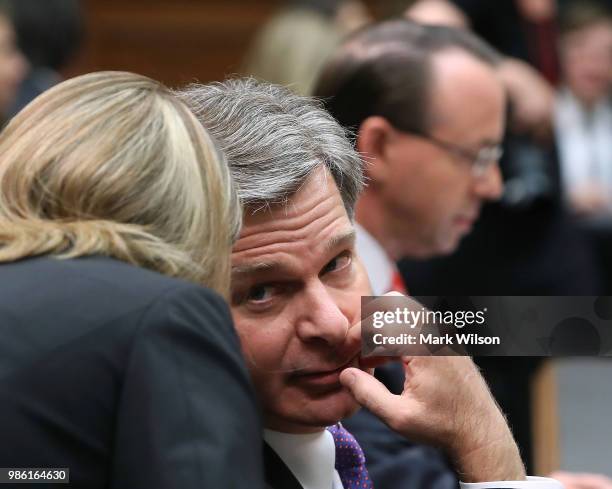 Director Christopher Wray speaks with a staff member while he and U.S. Deputy Attorney General Rod Rosenstein appear before the House Judiciary...