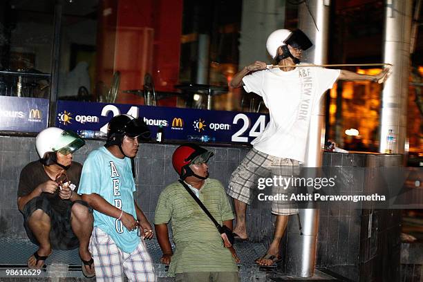 Pro-government protester uses a sling shot towards Red shirt anti-government protesters as tension rice at Silom street April 22, 2010 in Bangkok,...