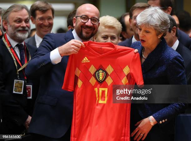Belgian Prime Minister Charles Michel gives a Belgian National Soccer team jersey to British Prime Minister Theresa May during an European Council...