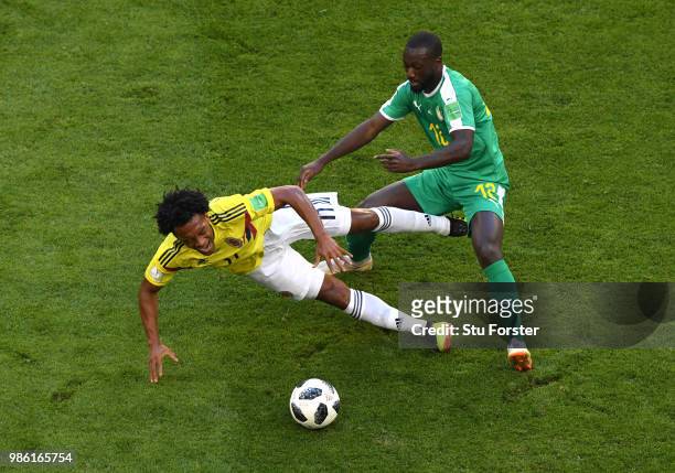 Juan Cuadrado of Colombia is challenged by Youssouf Sabaly of Senegal during the 2018 FIFA World Cup Russia group H match between Senegal and...