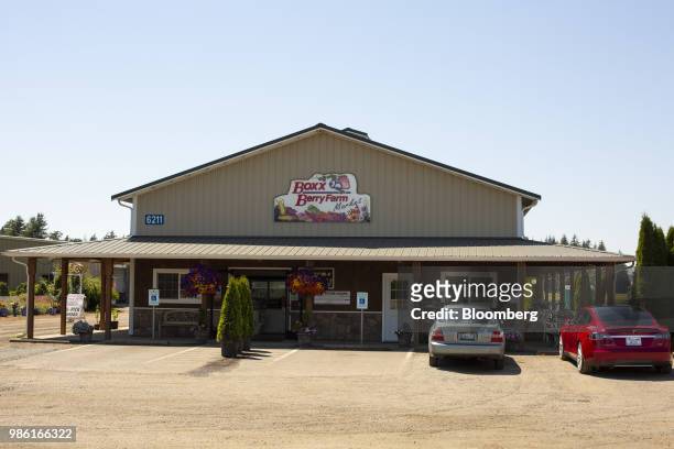 Vehicles sit parked outside the Boxx Berry Farm store in Ferndale, Washington, U.S., on Monday, June 18, 2018. A plan to move quickly on...