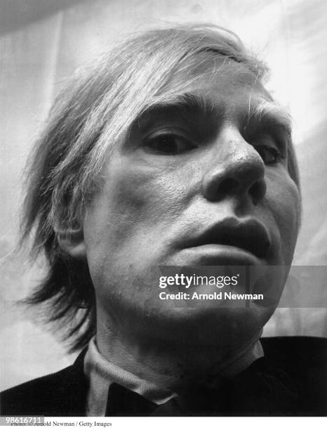 Low-angle, close-up portrait of American Pop artist Andy Warhol as he poses in his studio, the Factory, New York, New York, February 2, 1973.