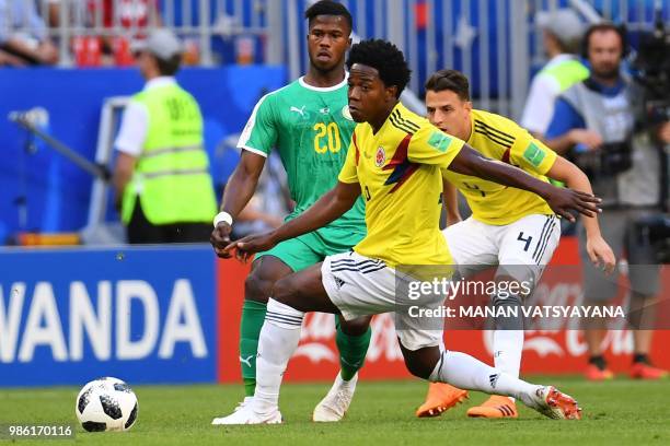 Colombia's midfielder Carlos Sanchez eyes the ball next to Senegal's forward Keita Balde and Colombia's defender Santiago Arias during the Russia...