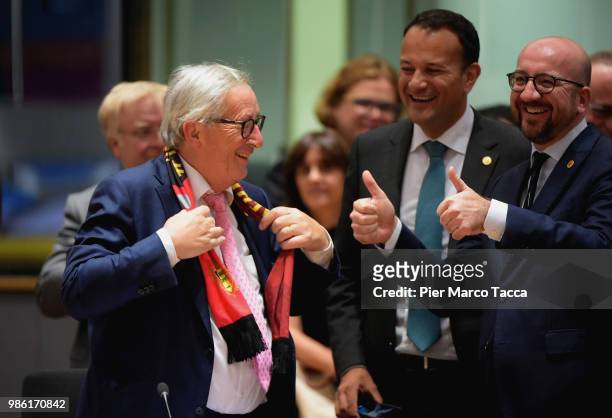 Jean-Claude Juncker, President of European Commission shows the scarf of the Belgian soccer team to Charles Michel, Prime Minister of Belgium during...