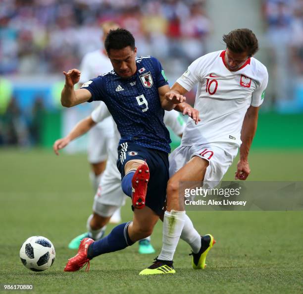 Grzegorz Krychowiak of Poland tackles Shinji Okazaki of Japan during the 2018 FIFA World Cup Russia group H match between Japan and Poland at...