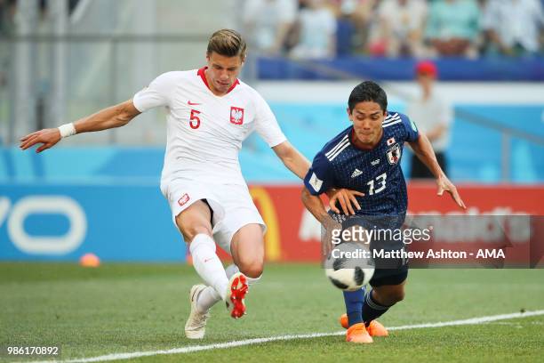 Jan Bednarek of Poland competes with Yoshinori Muto of Japan during the 2018 FIFA World Cup Russia group H match between Japan and Poland at...