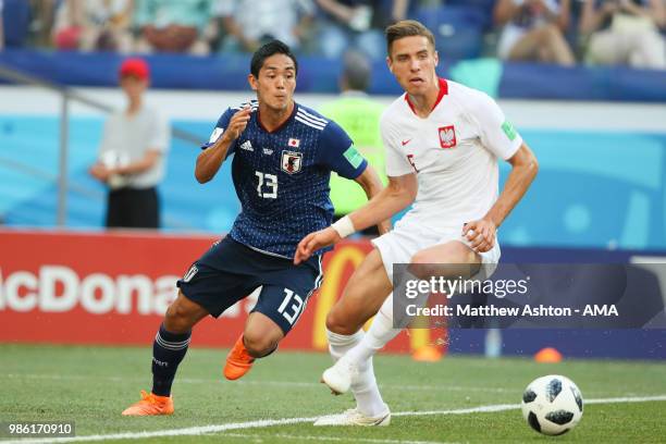 Jan Bednarek of Poland competes with Yoshinori Muto of Japan during the 2018 FIFA World Cup Russia group H match between Japan and Poland at...