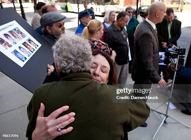 Patricia Gallagher Marchant, an abuse victim, hugs friend Russell Breghauer , while Peter Isely , Midwest Director of SNAP , along with victims of...