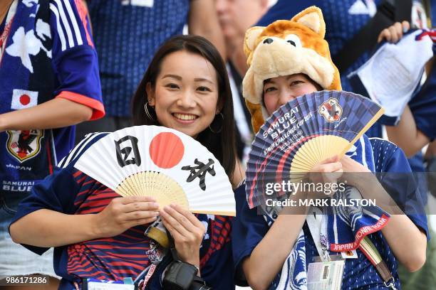 Japan's fans pose with their fans before the Russia 2018 World Cup Group H football match between Japan and Poland at the Volgograd Arena in...