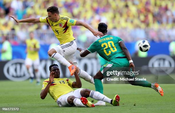 Santiago Arias of Colombia collides with Yerry Mina of Colombia as he is challenged by Keita Balde of Senegal during the 2018 FIFA World Cup Russia...