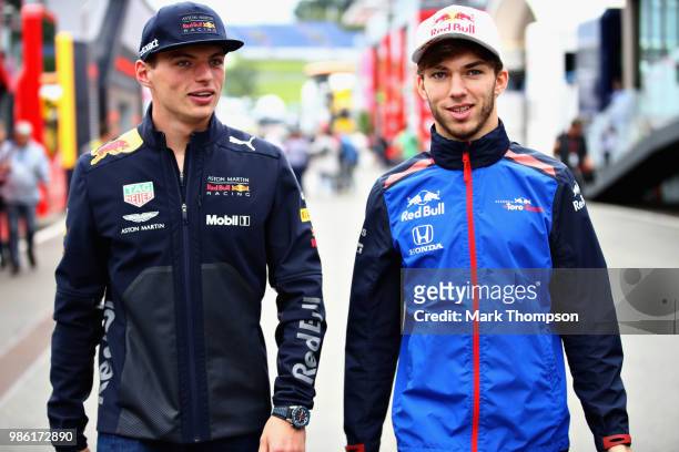 Max Verstappen of Netherlands and Red Bull Racing talks with Pierre Gasly of France and Scuderia Toro Rosso in the Paddock during previews ahead of...