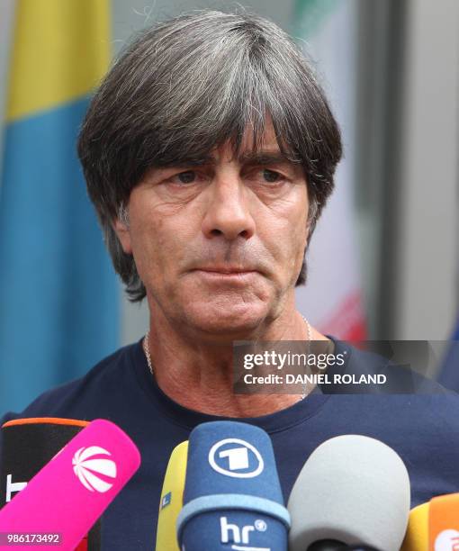 Germany's head coach Joachim Loew talks to media as he arrives at Frankfurt international airport on June 28 after flying back from Moscow following...