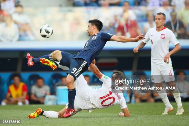 Shinji Okazaki of Japan is challenged by Grzegorz Krychowiak of Poland during the 2018 FIFA World Cup Russia group H match between Japan and Poland...