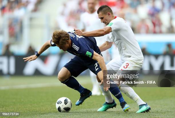 Gotoku Sakai of Japan challenge for the ball with Artur Jedrzejczyk of Poland during the 2018 FIFA World Cup Russia group H match between Japan and...