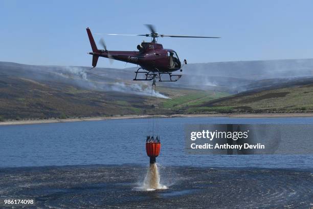 Helicopter collects water from Swineshaw reservoir in Stalybridge as wildfires continue to burn on the moors on June 28, 2018 in Stalybridge,...