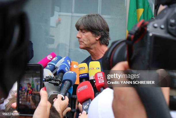 Germany's head coach Joachim Loew talks to media as he arrives at Frankfurt international airport on June 28 after flying back from Moscow following...