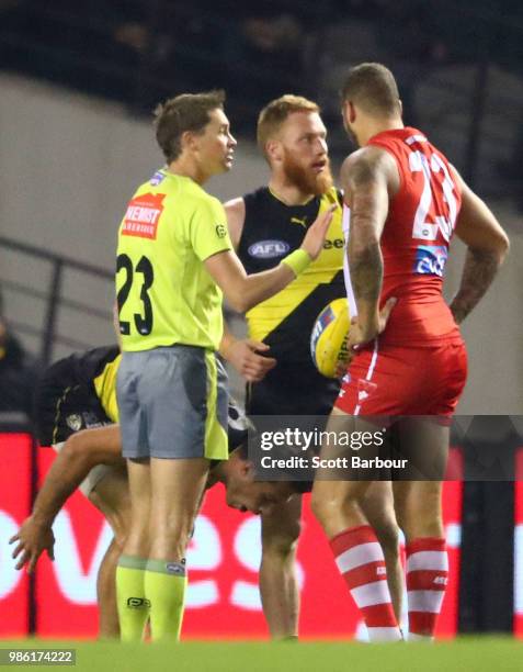 The umpire speaks to Lance Franklin of the Swans after he hit Alex Rance of the Tigers in the throat during the round 15 AFL match between the...