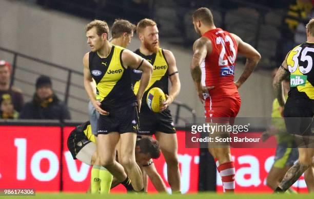 The umpire speaks to Lance Franklin of the Swans after he hit Alex Rance of the Tigers in the throat during the round 15 AFL match between the...